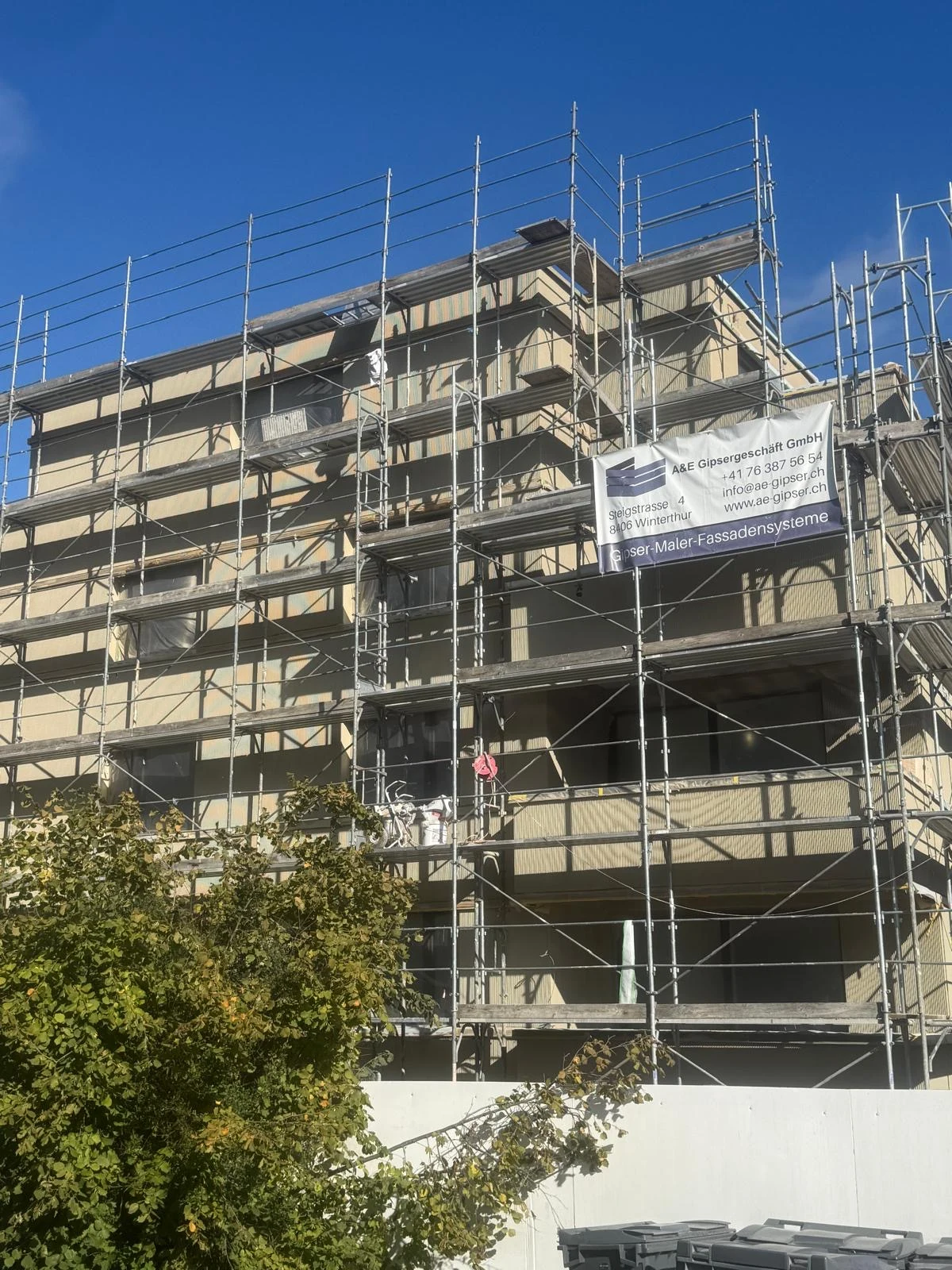 Ausgeführtes Projekt: Fassadenbaustelle mit Gerüst und A&E-Firmenbanner